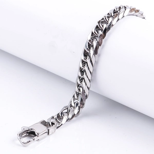 Macro view of a polished stainless steel Cuban chain link bracelet with a lobster clasp
