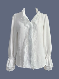 Detail of V-neckline with delicate lace ruffles and embroidery on white long sleeve shirt