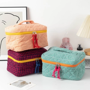 Three-piece quilted cotton cosmetic bags with portable handles and colorful zippers