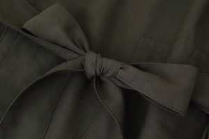 Détail du nœud de ceinture sur l'ensemble veste et pantalon large de couleur olive