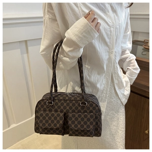 Detail view of brown vintage shoulder bag with dual front pockets and monogram pattern
