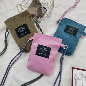 Detailed view of corduroy texture and woven straps on multi-colored mini crossbody bags