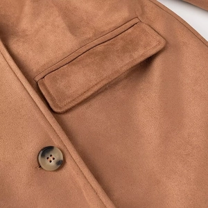 Detail of brown faux suede coat featuring side pocket, buttons, and soft textured fabric