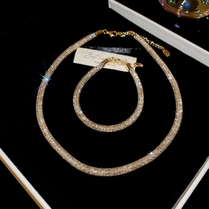 Detailed view of champagne gold mesh necklace and bracelet set with sparkling zircon details