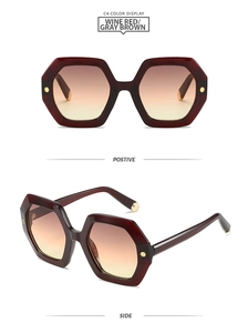 Detail view of hexagonal wine red sunglasses with gold rivet accents and gradient lenses