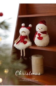 Detail of plush Christmas doll ornaments with red and white fabric on a warm wooden shelf