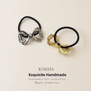 Detail of gold and silver alloy bow hair ties with high elasticity black bands