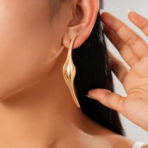 Close-up of a gold-finish irregular fluid drop earring with a sleek metallic texture