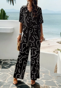 Detail of a two-piece vacation set featuring white abstract patterns on black fabric