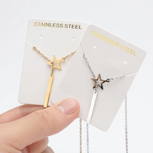 Detail of stainless steel star and bar pendant necklaces in gold and silver finish