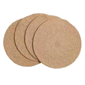 Set of four circular braided jute placemats with natural woven texture for dining table