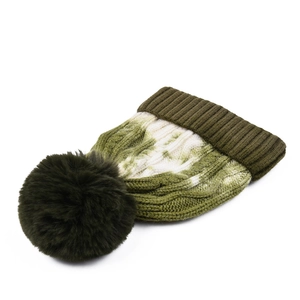 Close-up of olive green tie-dye cable knit beanie with large faux fur pompom detail