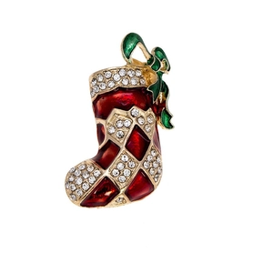 Detail einer roten Emaille-Weihnachtssocken-Brosche mit Kristallen und grüner Schleife
