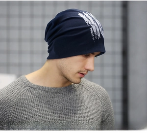 Detail of navy blue knitted beanie with white abstract print on a model in side view