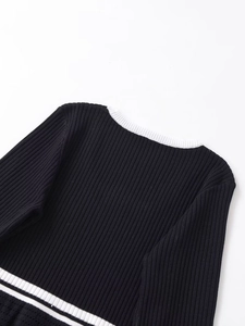 Detail of contrast rib-knit collar and shoulders on black and white knit sweater