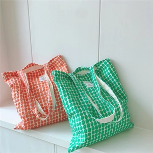 Large cotton tote bags with geometric dot patterns in orange and green colors