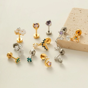 Micro-inlaid zircon stainless steel cartilage earrings collection on stone display