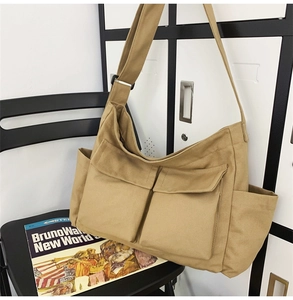 Khaki canvas crossbody bag with large front pockets and adjustable shoulder strap