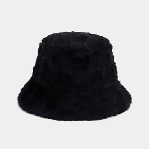 Detail shot of black fuzzy faux fur bucket hat with soft plush texture for winter warmth