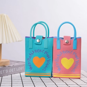Detail of cute knitted handbags with heart patterns and premium leather handles