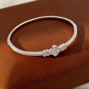 Detailed macro view of silver clover bracelet with zircon pavé setting on velvet box