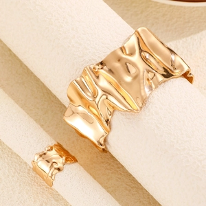 Vista detallada del conjunto de joyas doradas con brazalete martillado y anillo a juego