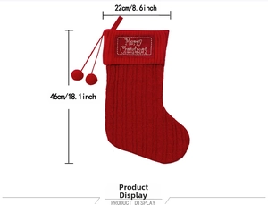 Detail view of large red cable knit Christmas stocking with pom-poms and sizing info