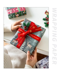 Close-up of hands holding festive red and green Christmas wrapping paper with silk ribbons