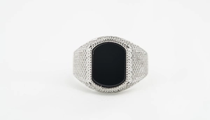 Detail of vintage punk men's titanium steel ring featuring black onyx and textured band