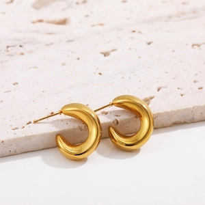 Close-up of chunky 18K gold plated stainless steel C-shape earrings with a polished finish