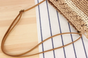 Détail d'un sac en paille tissé à la main avec bandoulière en cuir réglable
