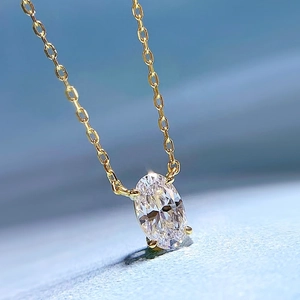 Macro view of gold chain necklace with oval cut gemstone pendant showing sparkle details