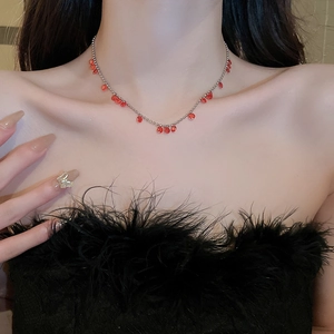 Gros plan d'un collier argenté élégant avec perles rouges sur une femme