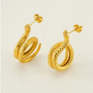 Macro detail of golden stainless steel snake earrings with fine scale texture