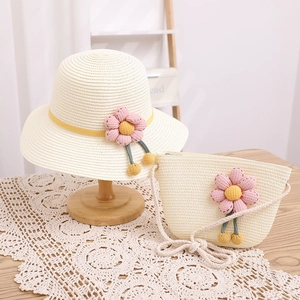Détail de l'ensemble chapeau et sac en paille avec marguerites roses et texture tressée