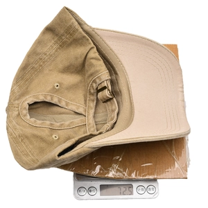 Detail view of khaki washed cotton ponytail baseball cap on scale showing 72.5g weight