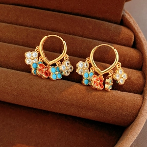 Detail of vintage gold plated earrings with zircon flower tassels and colored gemstones