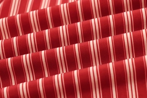 Macro shot of red and cream striped woven fabric showing detailed texture and soft folds