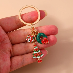 Detail of Christmas keychain featuring gold metal rings with gift box and tree pendants