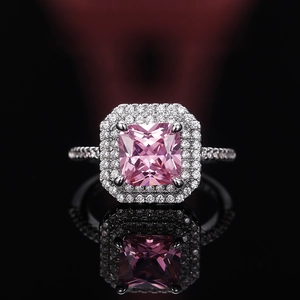 Macro detail of luxury pink square zircon ring with double halo and silver band