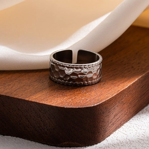 Detailed close-up of a hammered texture stainless steel wide band ring with beaded edges