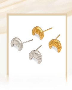 Détail de boucles d'oreilles croissant dorées et argentées à texture spirale chic