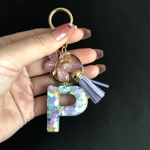 Detail of resin letter P keychain with heart sequins, purple butterfly and tassel