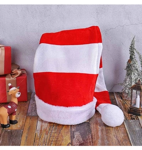 Detail of red and white striped long Christmas hat with soft plush pompom and velvet texture