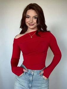 Detail of red off-shoulder slim top featuring asymmetrical neckline and draped fabric