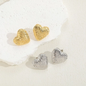 Detail of heart-shaped earrings with woven texture in gold and silver finish