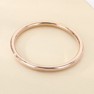 Detailed macro view of 18k gold plated stainless steel hollow bangle with mirror finish