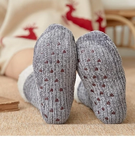 Detailed close-up of dark grey knitted thermal socks featuring red heart non-slip soles