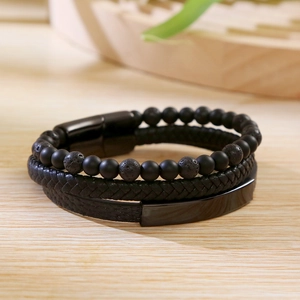 Close-up of multilayer men's bracelet with black leather, beads, and stainless steel clasp