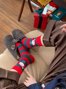 Detail of festive Christmas cotton socks with red stripes and Santa Claus cartoon motif